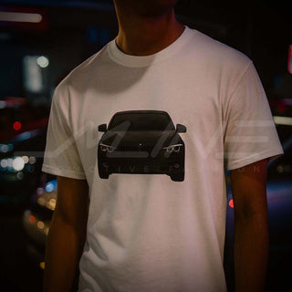 Male model wearing M Sedan Cartoon Tee at night-time car meet with neon-lit modified cars