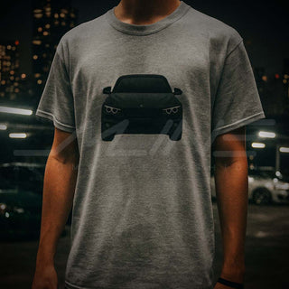 Male model wearing M Sedan Cartoon Tee at night-time car meet with neon-lit modified cars