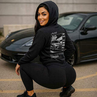 Female model crouching in black M Line Manga Series Vol. 01 hoodie, Sport SV manga artwork visible on back.