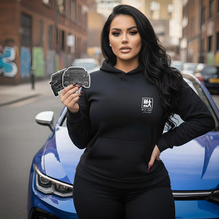 Lifestyle shot of custom car air freshener 2-pack held by model wearing M Line Automotive hoodie
