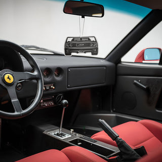 Ferrari F40 rear silhouette air freshener hanging from rear-view mirror inside vintage performance car interior