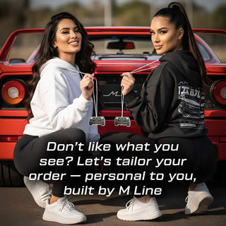 Two models holding Ferrari F40 V8 silhouette air fresheners in front of red exotic car – M Line lifestyle branding