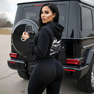 Model showcasing Mercedes G Wagon G63 G-Series silhouette air freshener next to black premium SUV rear