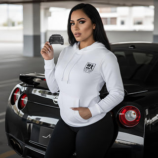 Model holding R35 silhouette air freshener while standing beside black nissan gtr r35