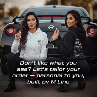 Two models holding R35 silhouette air fresheners in front of black Nissan GTR R35 – M Line lifestyle branding